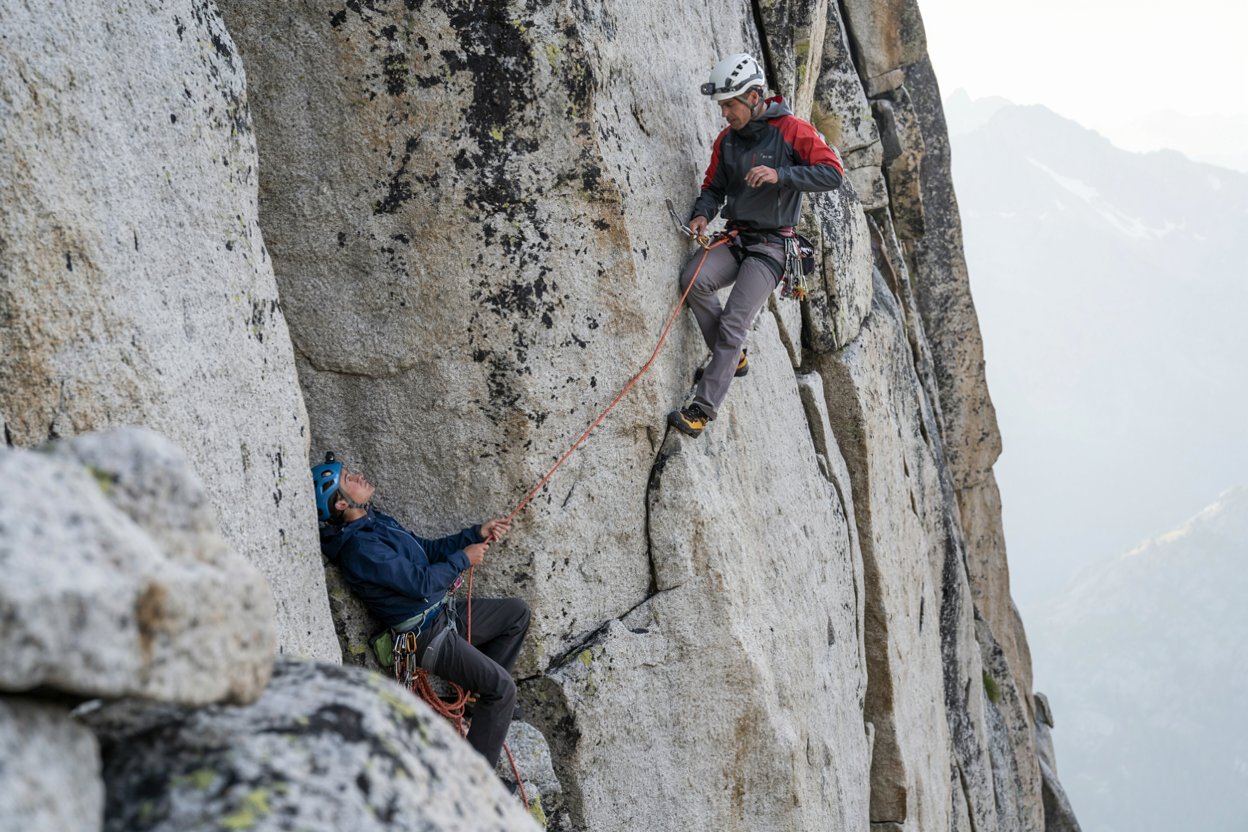 Deux alpinistes en cordée escaladent une paroi verticale
